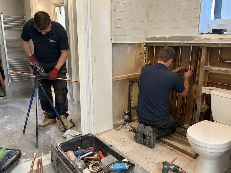 Plombiers rénovant la plomberie d’une salle de bain